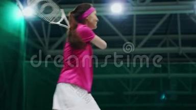 一个穿着粉红色T恤和白色裙子的女人在网球比赛中打球。 网球运动员学会打球